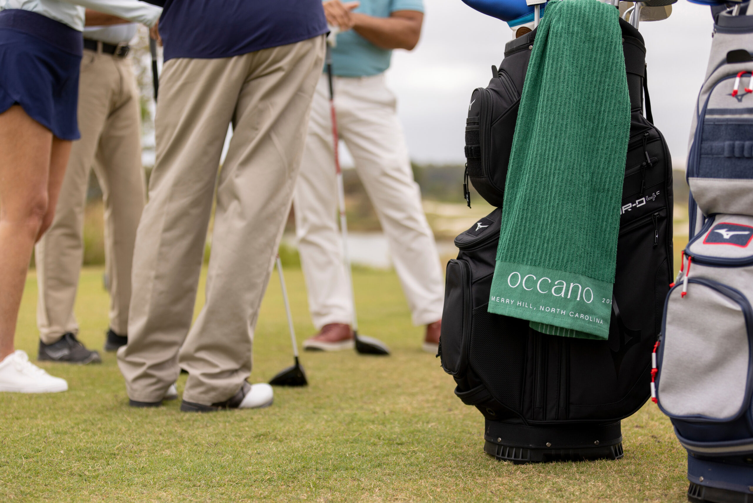 Group of golfers around a golf bag
