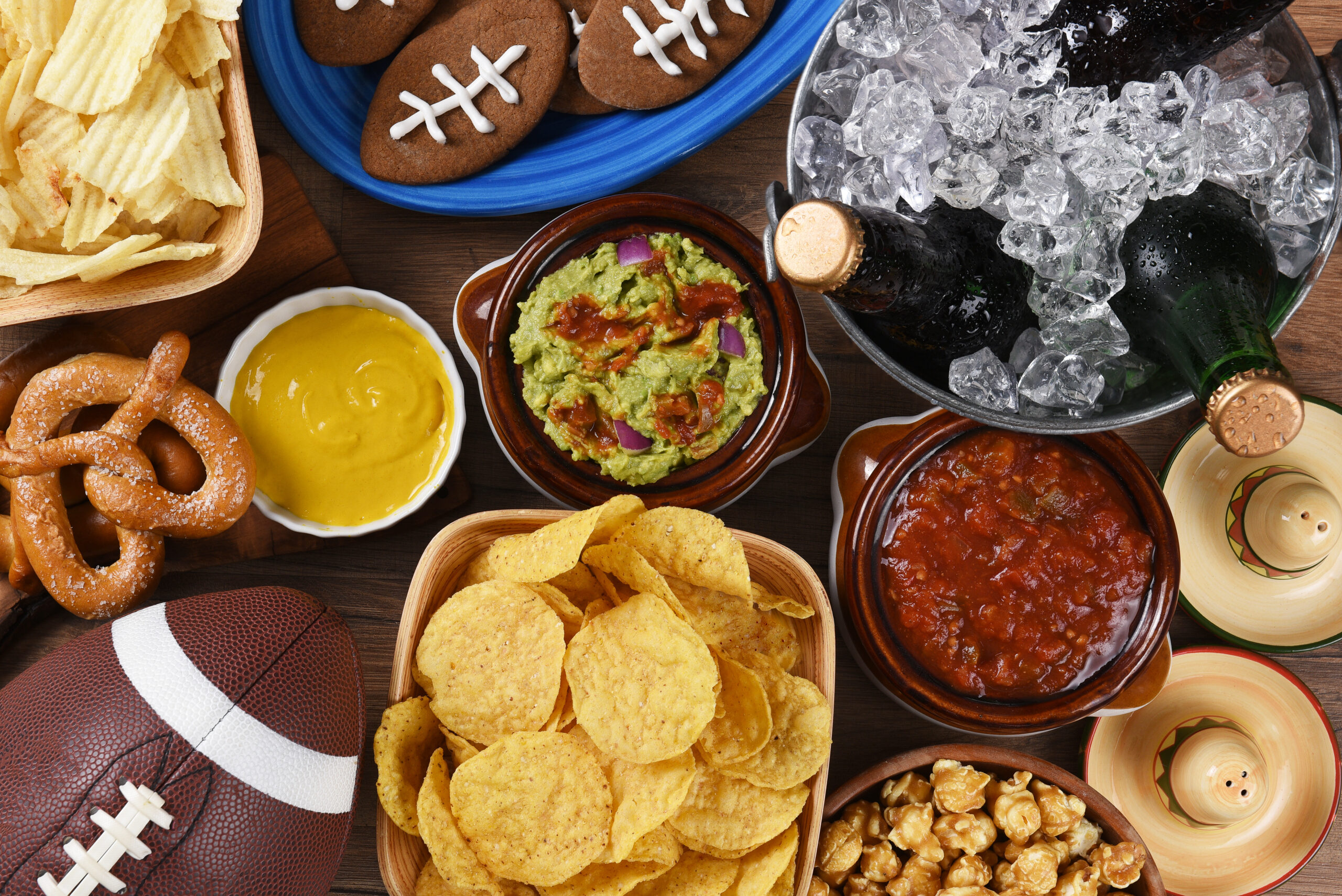 Top view of snacks and drinks laid out for a football watching party.