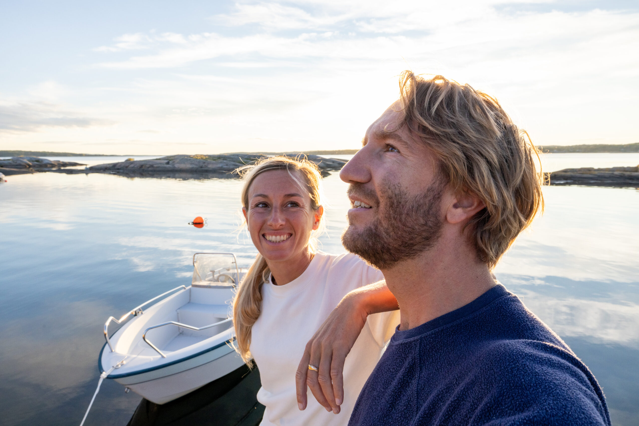 Couple relaxing on pier above lake at sunset